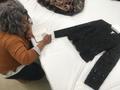 Photograph: [Student sketching a garment on display]