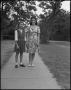 Photograph: [Woman stands with a younger woman]