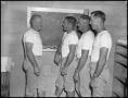 Photograph: [Coach talking to three football players]