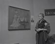 Photograph: [A woman in front of a museum painting]
