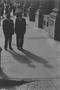 Primary view of [Two men standing on a busy sidewalk, 2]