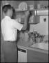 Photograph: [Man in Kitchen with Cup]