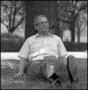 Photograph: [Dr. Wayne Adams lounges beneath a tree]