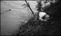 Photograph: [Man sleeping on a river bank]