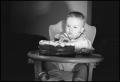 Photograph: [Baby holding a candle covered in frosting]