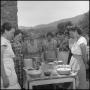 Photograph: [Photograph of seven women standing around a set table]