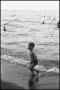 Photograph: [Young boy playing on the shore]