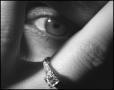 Photograph: [Photograph of a woman's eye peeking from behind her fingers]