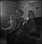 Photograph: [Three children seated on a classroom bench]