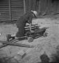 Photograph: [Boy removing nails from a cart]