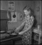 Thumbnail image of item number 1 in: '[A woman cooking with a skillet]'.