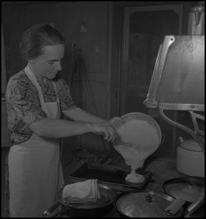 Primary view of object titled '[A woman pouring batter]'.