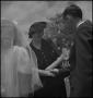 Photograph: [Iris Clark congratulating the bride and groom]
