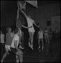 Photograph: [Basketball in the air as two players jump for it]