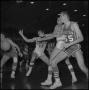 Photograph: [Basketball players reaching for the ball]