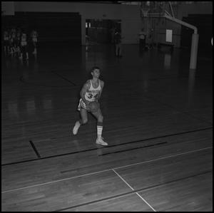 Primary view of object titled '[Jim Struck running up with a basketball]'.