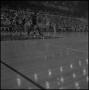 Photograph: [NTSU basketball player dribbles the ball as St. Louis player blocks …