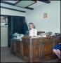 Photograph: [Woman sits at an office desk]