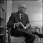 Photograph: [Dean A. Witt Blair sitting in a chair with a book in his lap]