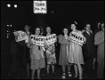 Photograph: [Women holding newspapers about the end of WWII]