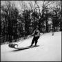 Photograph: [Woman sledding down a hill standing up]