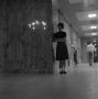 Photograph: [Betty Chapman standing in a hall]