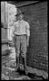 Primary view of [Byrd Williams, Jr. standing outside a darkroom]