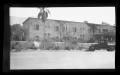 Photograph: [An automobile parked in front of a building]