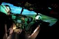 Primary view of [Two pilots in a flight simulator pod]