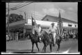 Photograph: [Woman on Horseback with Texas Flag & Man on Horseback with American …