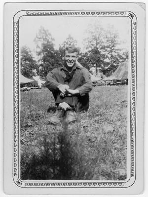 Primary view of object titled '[Man relaxes in front of the CCC camp tents]'.