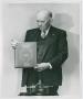 Photograph: [Dr. Felix P. Miller with Book and X-ray Tube]