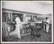 Photograph: [Two Men Working at Johnnie Johnson Tire Co.]