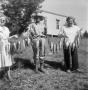 Photograph: [Three People Holding a String of Fish]