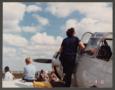 Photograph: [Gayle Snell and child on warbird wing]