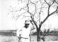 Photograph: [Photograph of Manuel Reyes, Jr. leaning on a tree]