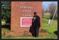 Primary view of [Photograph of Reginald Moore with the Central State Farm Prison Sign]