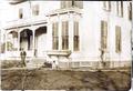 Photograph: [Man and two dogs in front of house]
