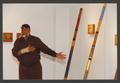 Primary view of [Alonzo Davis Gesturing Toward Displayed Artworks]
