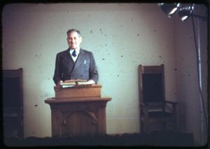 Primary view of object titled '[Photograph of Reverend J.S. Cantu Standing at Pulpit]'.