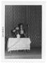 Photograph: [Woman on Stage Behind a Decorated Table]