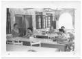 Photograph: [Group of Hispanic Women Working at Tables]