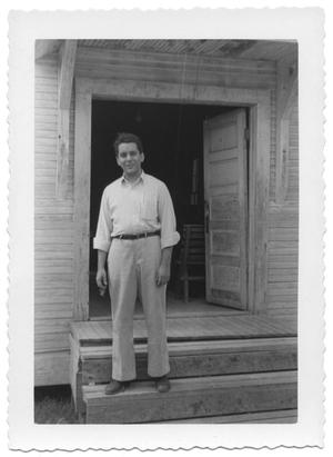 Primary view of object titled '[Man Standing on the Steps of a Wooden House]'.