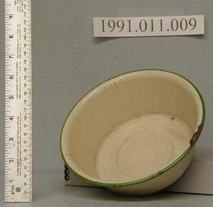 Primary view of object titled 'Beige enamel with green trim around lip.'.