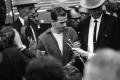 Photograph: [Lee Harvey Oswald being led from the midnight press showing]