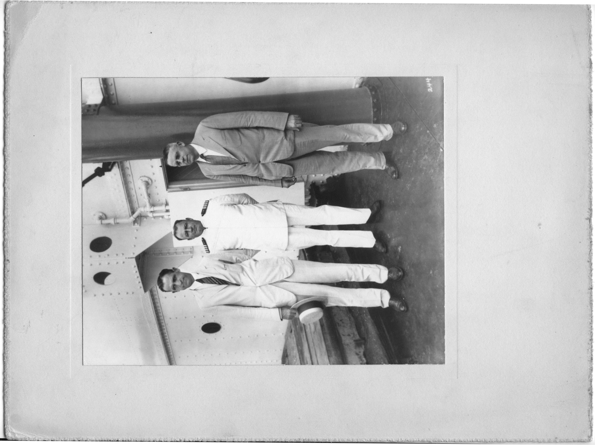 [Three unidentified men, one dressed as naval officer in front of doorway]
                                                
                                                    [Sequence #]: 1 of 1
                                                
