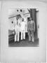 Primary view of [Three unidentified men, one dressed as naval officer in front of doorway]