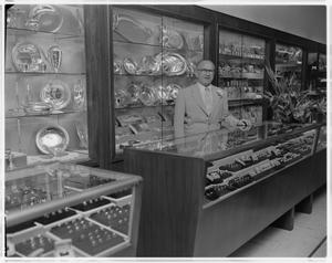 An unknown man stands behind the counter at a Zales Jewelers. The ...