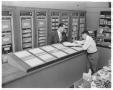 Photograph: [Don Abel helping customer at Abel Stationers]