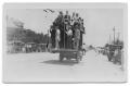 Photograph: [Men Riding on Truck in Parade]